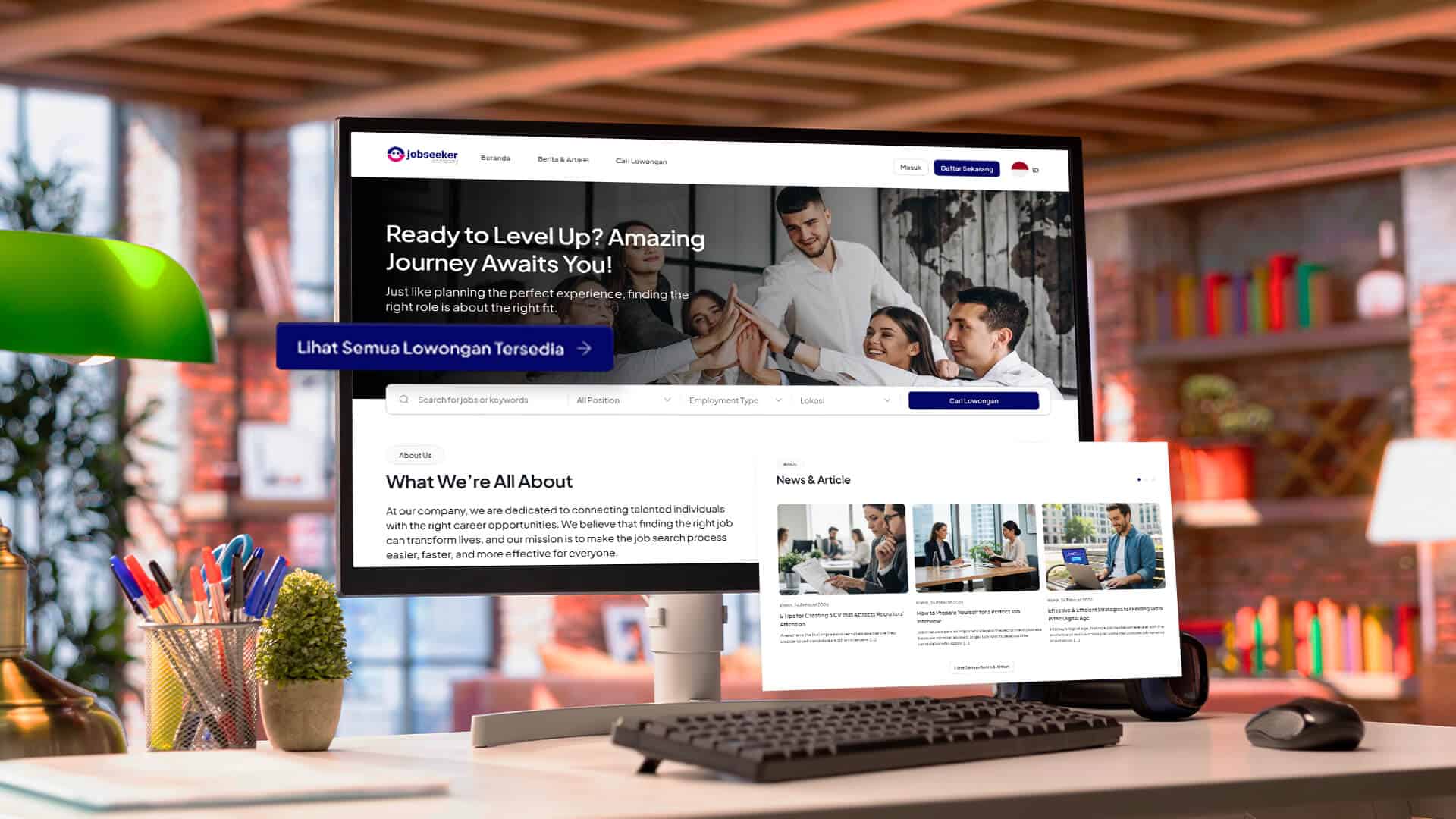 Monitor komputer di atas meja kerja menampilkan halaman situs web rekrutmen Jobseeker Company yang berisi informasi lowongan dan profil perusahaan.