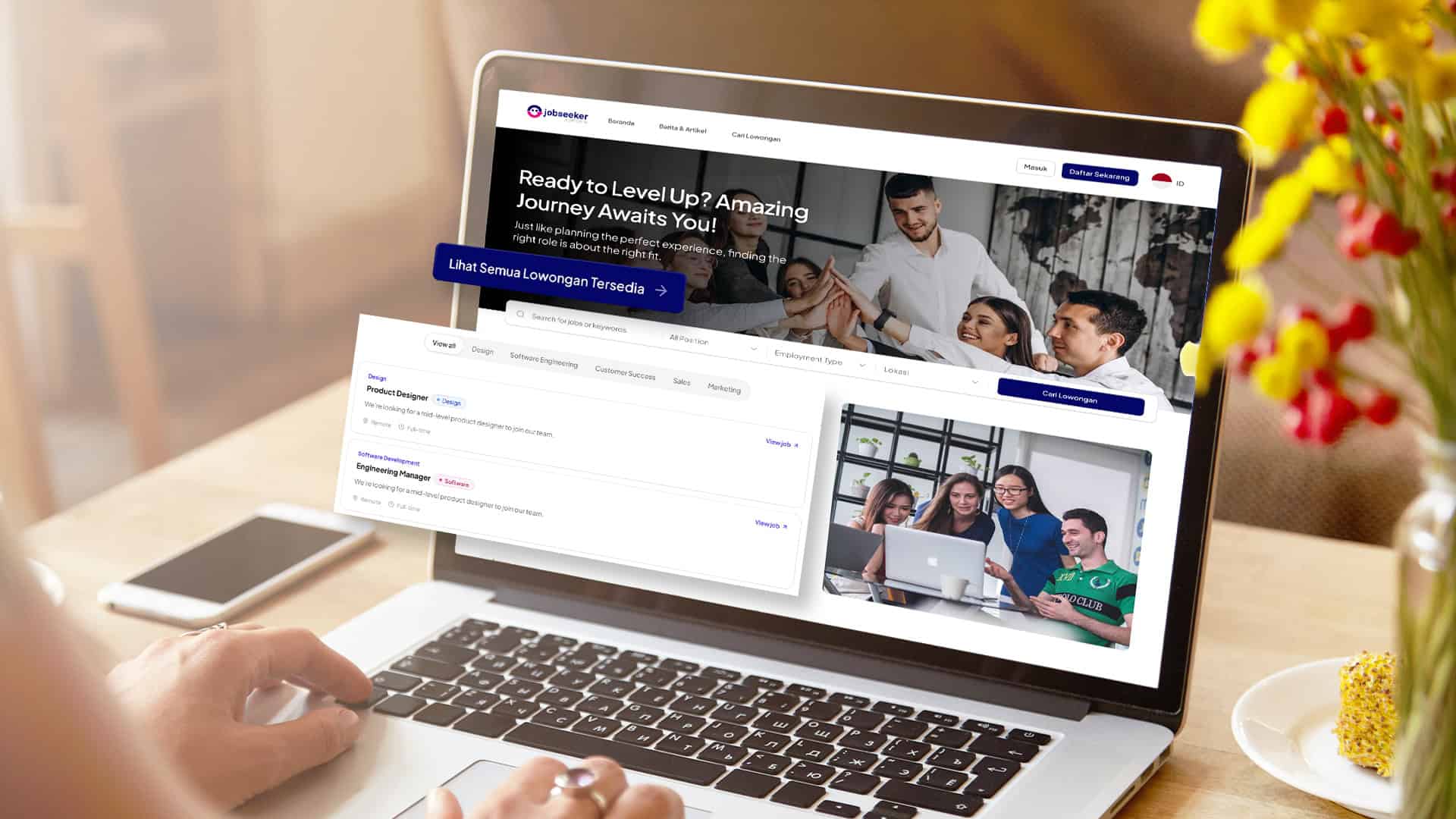 Seseorang menggunakan laptop yang menampilkan situs web rekrutmen dan daftar lowongan kerja di meja.